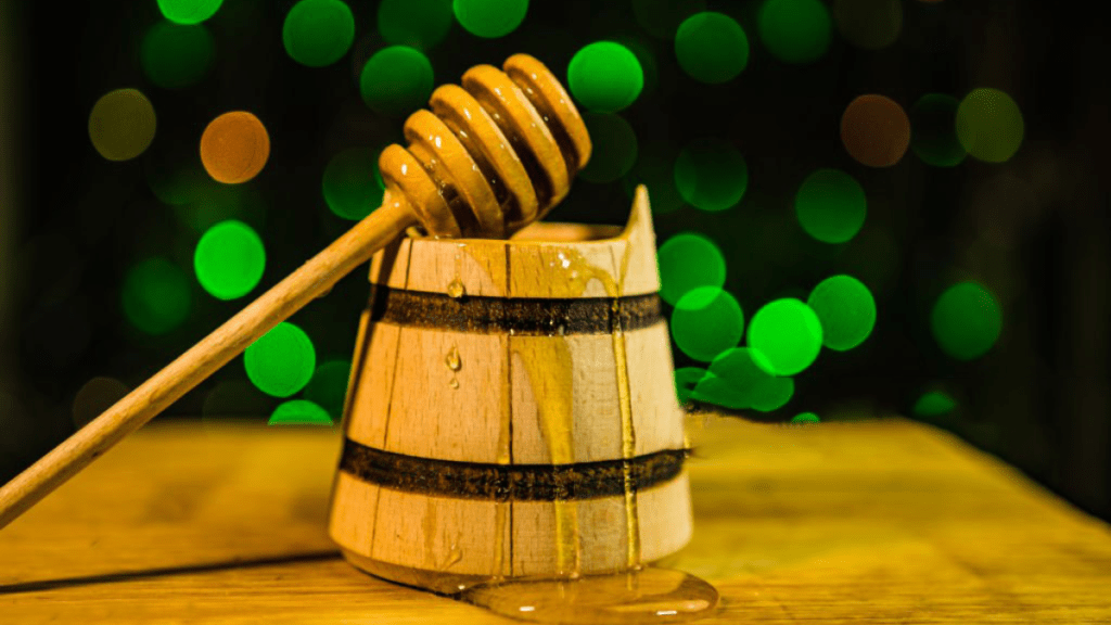 Wooden honey dipper for natural honey drizzling, sustainable utensil.